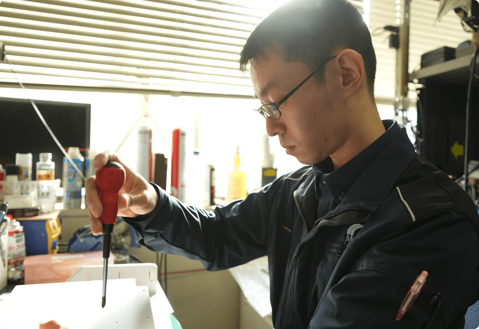 整備士が車両下部を点検している作業風景